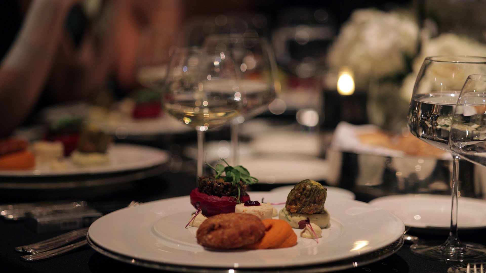 Elegant Fine Dining Experience at a Luxury Event. A beautifully plated dinner set on a luxurious table.